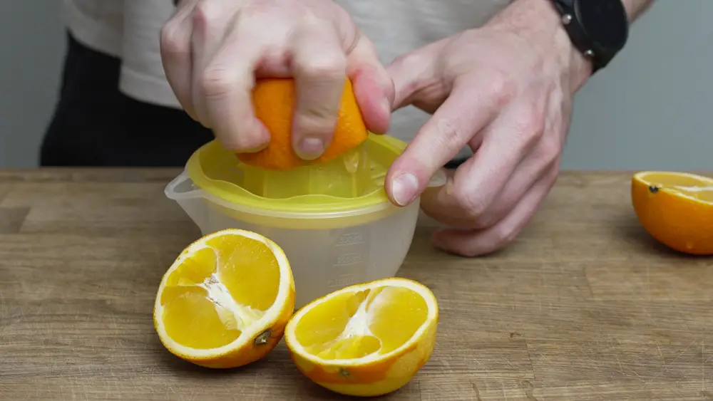 extracting orange juice with a citrus juicer