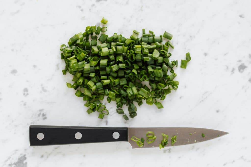 Chopped onion and knife on table